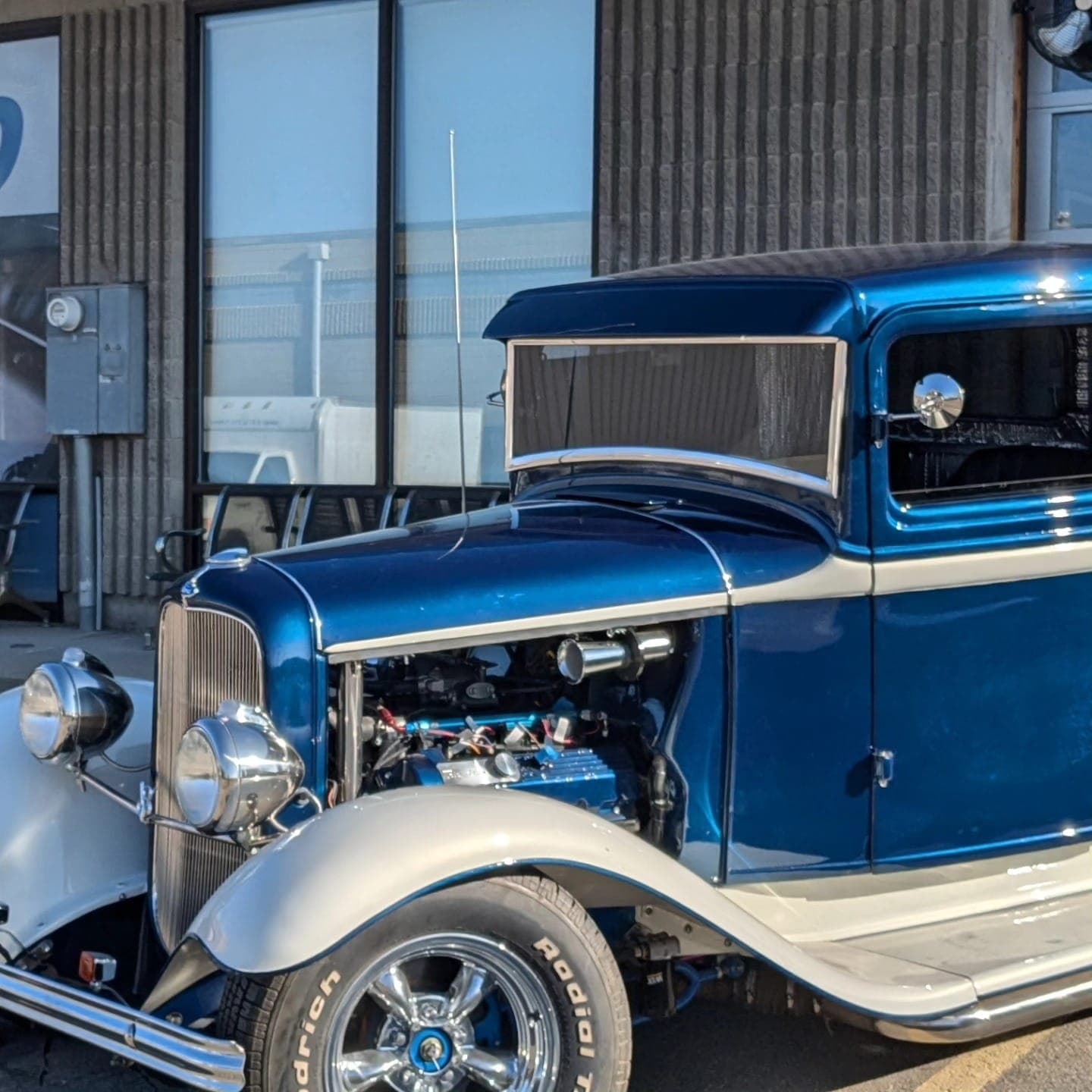 Blue 1934 Ford truck with the hood open outside Turbo Lab in Orem, UT