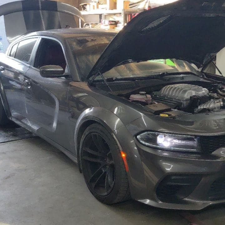 Supercharged Dodge Charger with the hood up in the shop at Turbo Lab in Orem