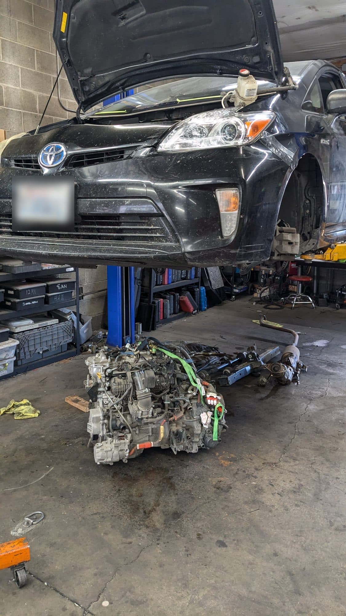 Toyota Prius on the lift with its engine out on the floor below at Turbo Lab in Orem, UT