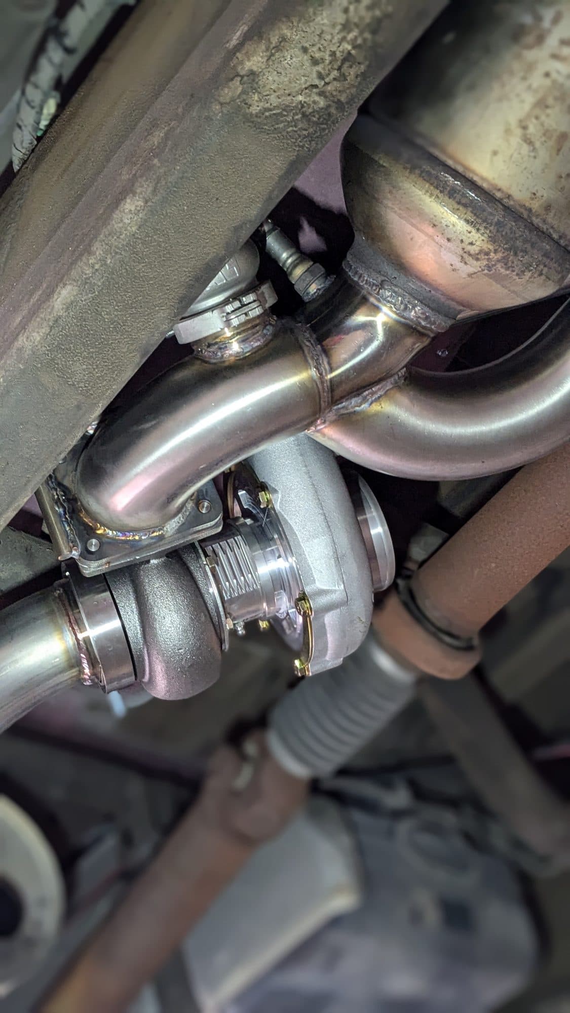 Turbocharger and downpipe installed under a truck at Turbo Lab in Orem, UT