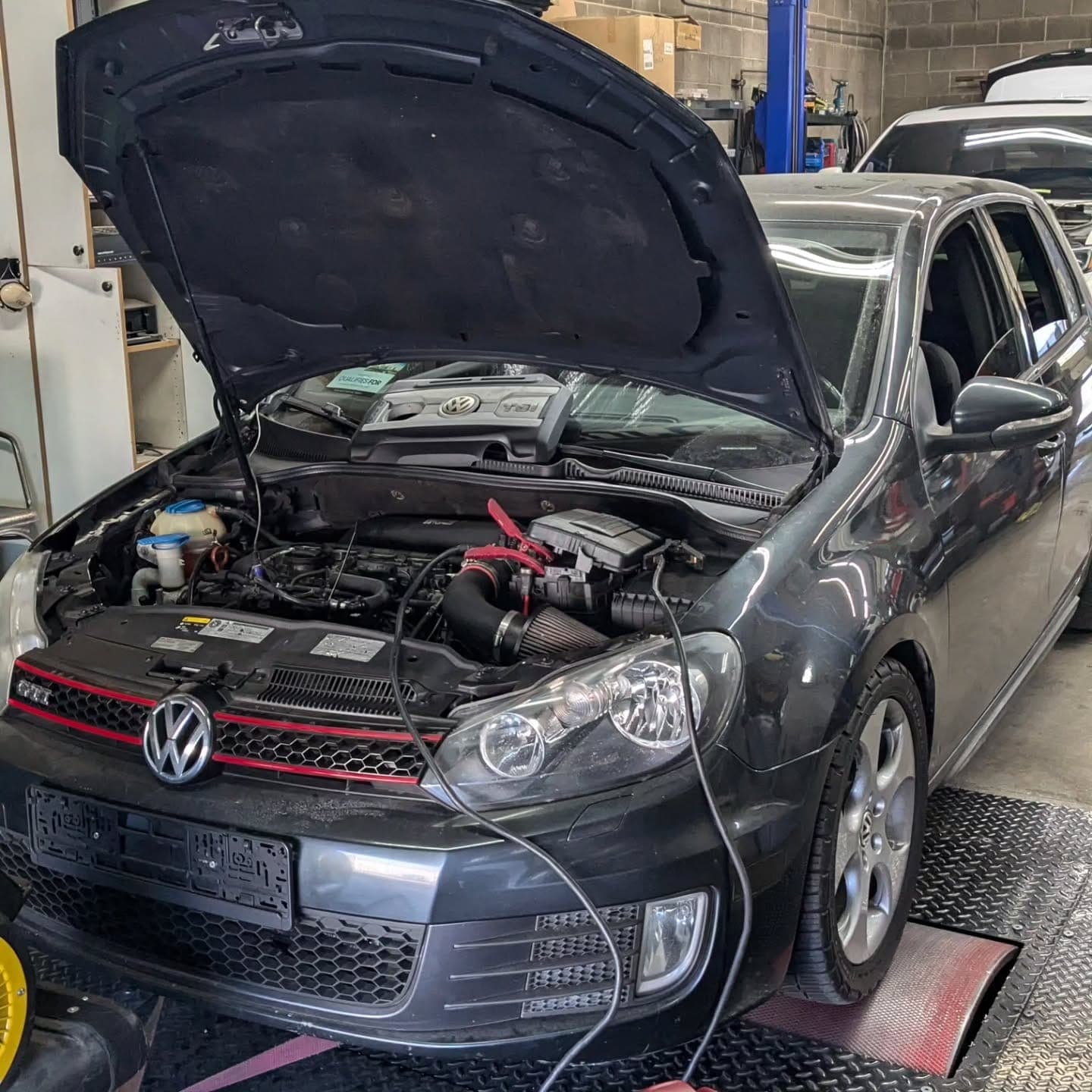 MK6 Volkswagen GTI on the dyno with the hood up and a tuning laptop connected at Turbo Lab in Orem