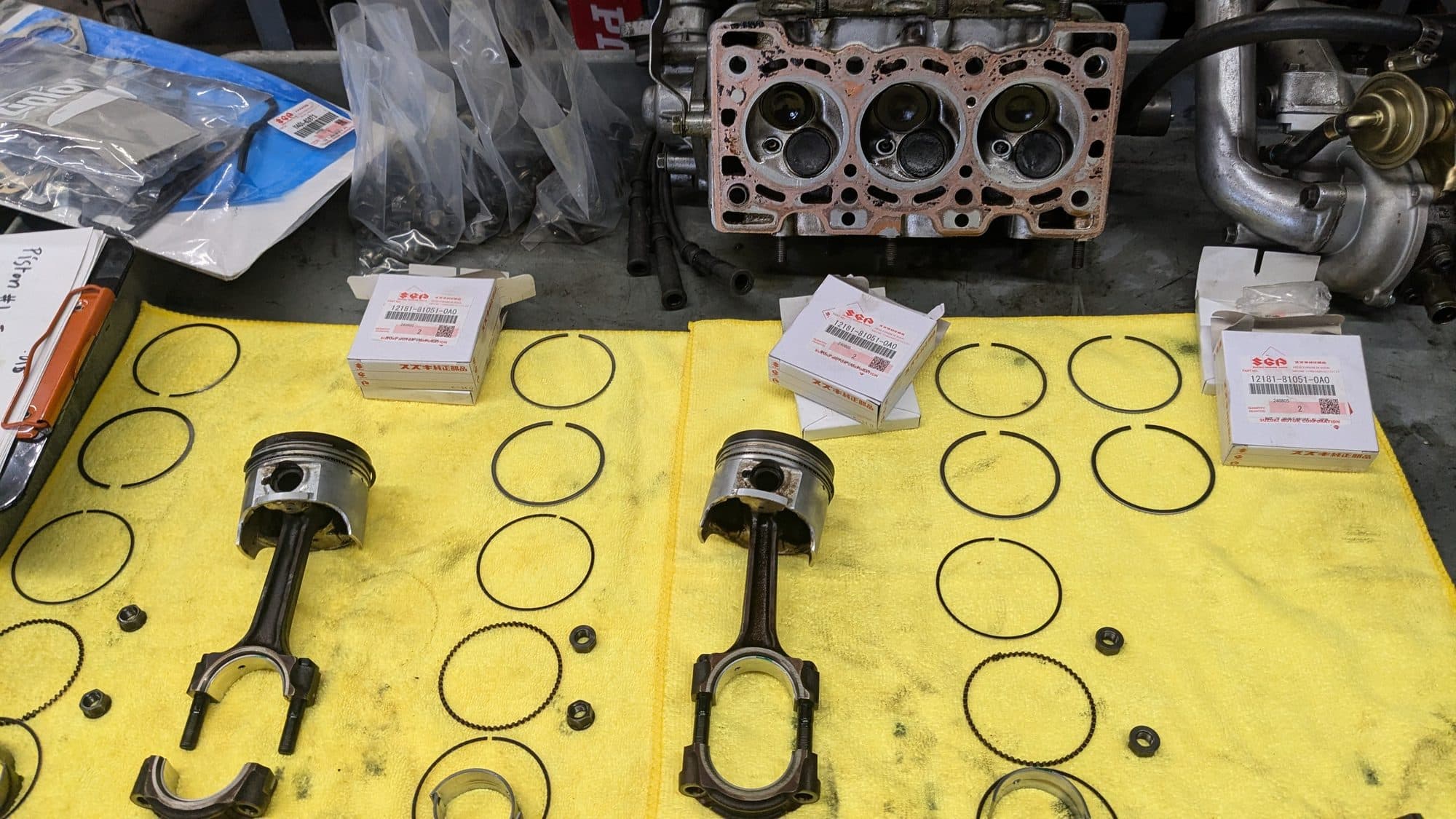 Forged pistons, rods, and a cylinder head laid out for an engine build at Turbo Lab in Orem, UT