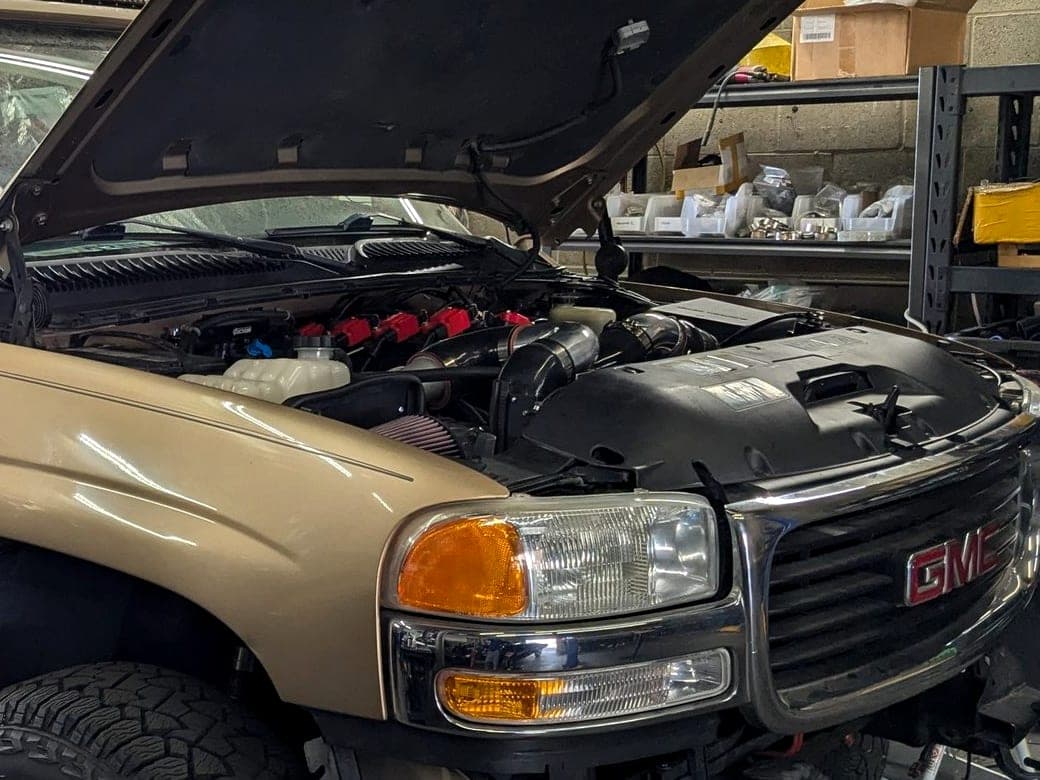 Open hood and engine bay of a GMC Yukon in for engine work at Turbo Lab in Orem, UT