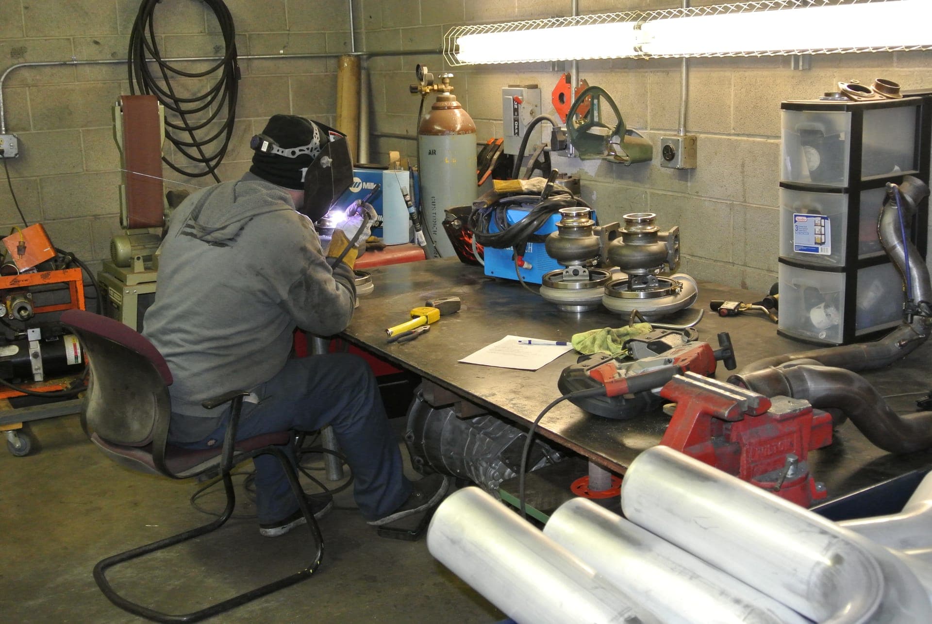 Turbo Lab tech TIG welding custom turbo parts at the fabrication bench in Orem, UT