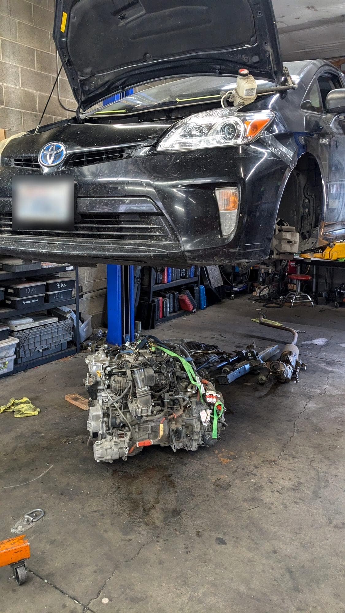 Toyota Prius on the lift with its engine out on the floor below at Turbo Lab in Orem, UT