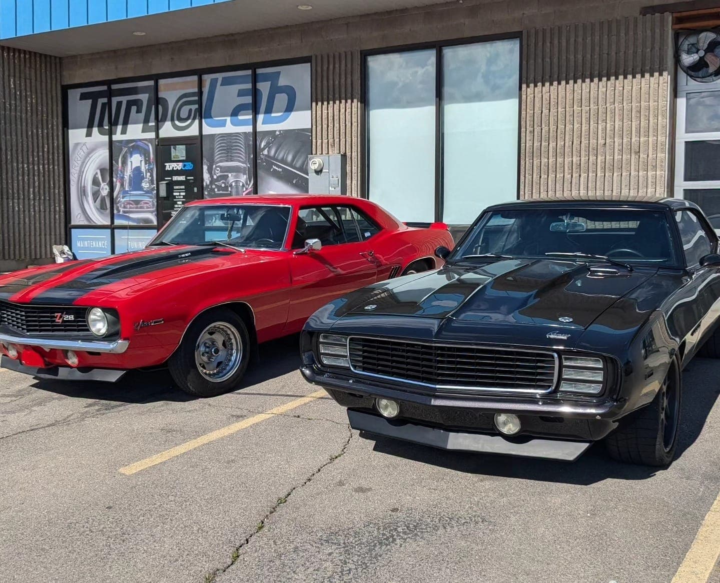 Two classic Chevy Camaros parked outside the Turbo Lab shop on Center Street in Orem, Utah