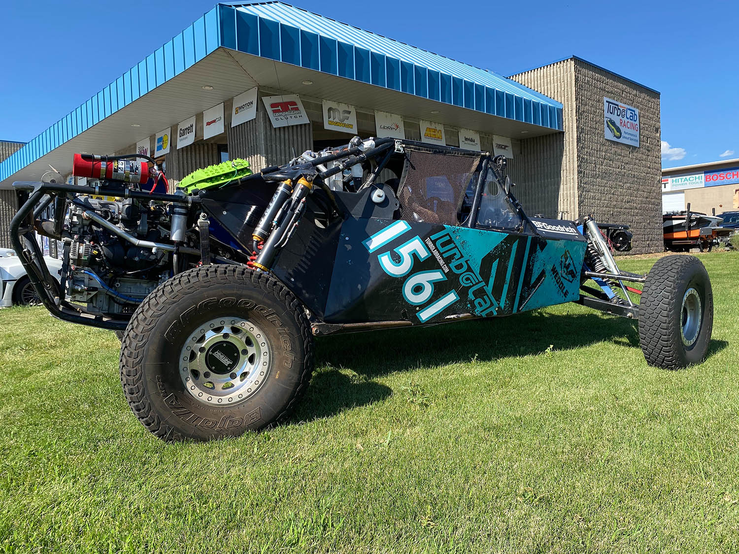 Image of a black and turquoise TurboLab Offroad Vehicle on green lawn